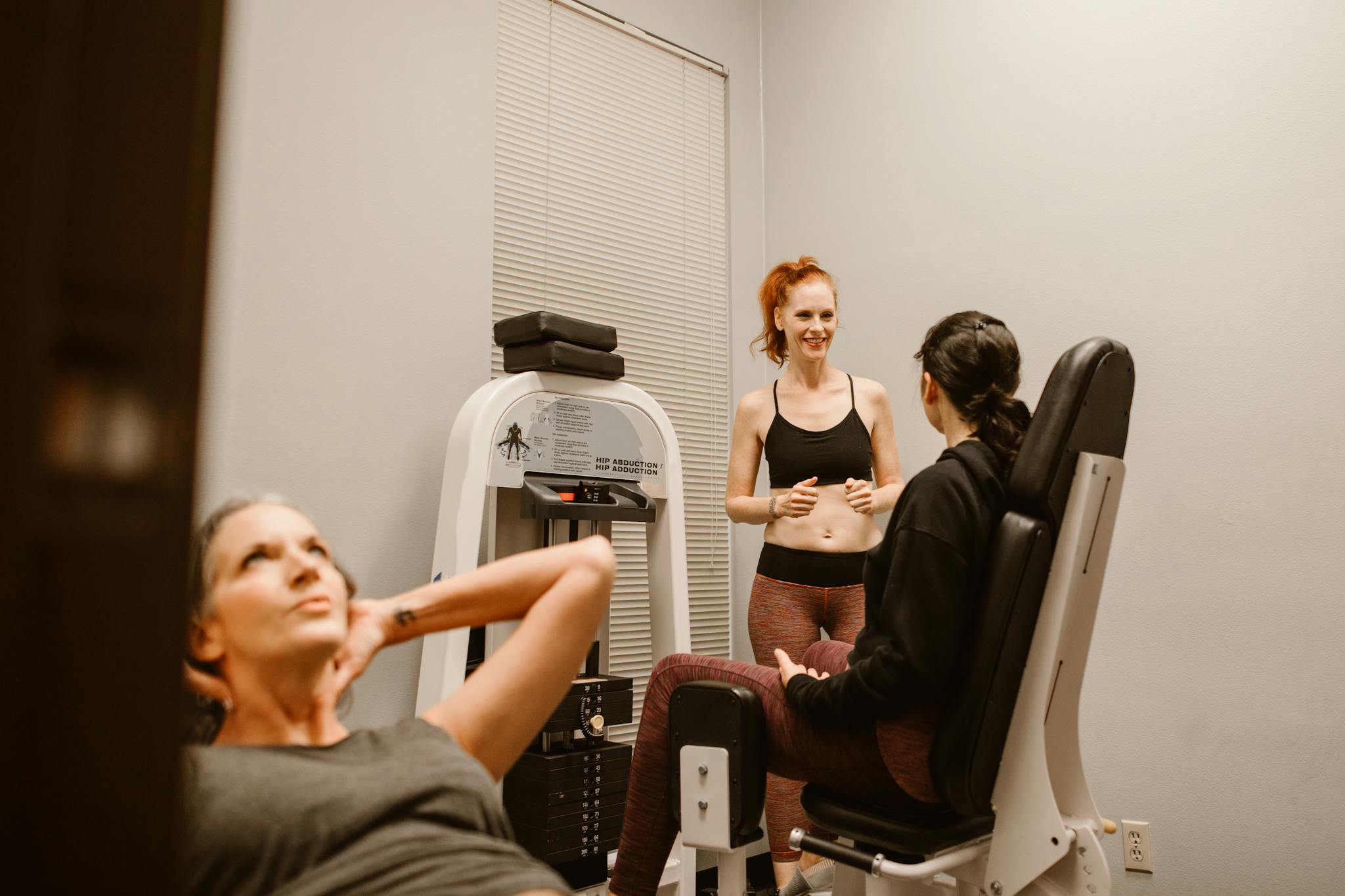Women engaging in fitness routines at an indoor gym, focusing on wellness and health.